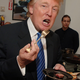 Donald Trump forks a piece of steak into his mouth